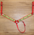 A Christmas-themed horse breast collar featuring red straps, a green patterned center panel and red trim.