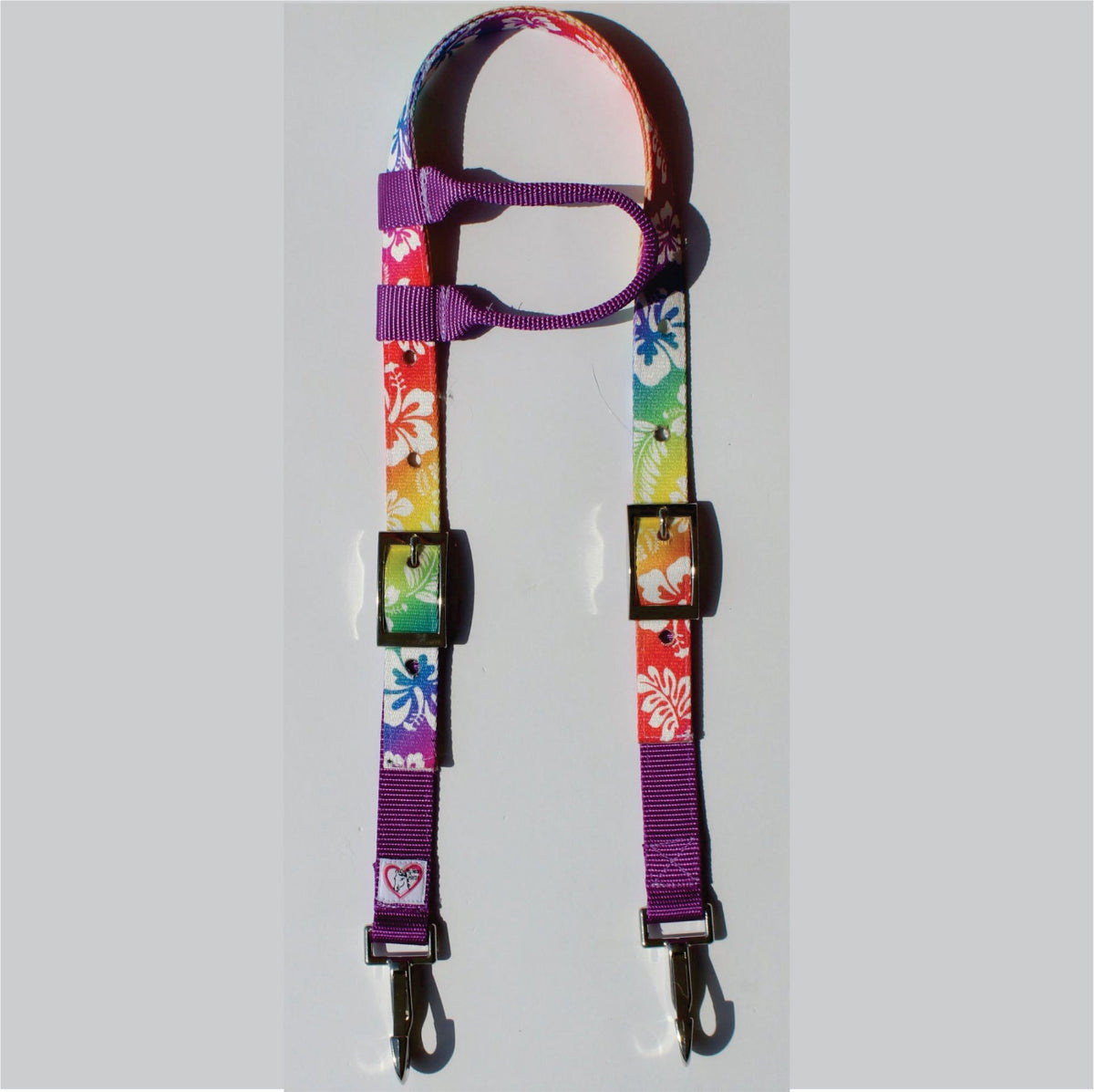 A colorful floral-patterned headstall with purple webbing and metal clips, .