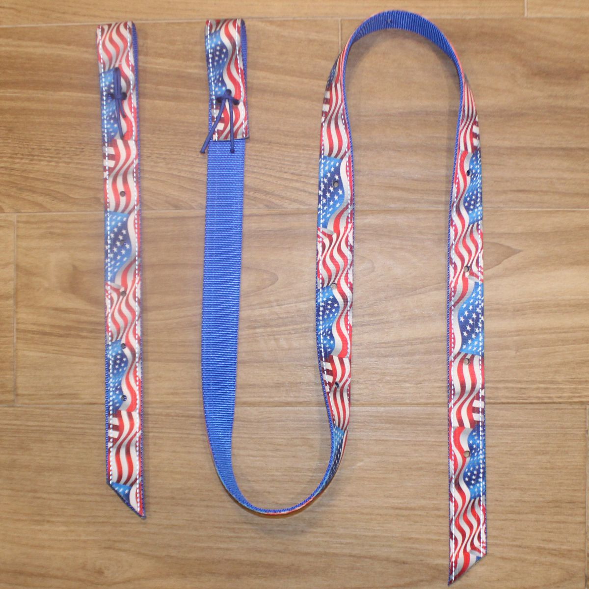 A patriotic-themed Latigo and Billet cinch set, featuring a blue center with red and white wavy stripes and white stars on the ends.