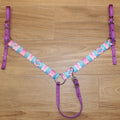 A western-style horse breast collar with a colorful geometric patterned strap and solid purple webbing straps
