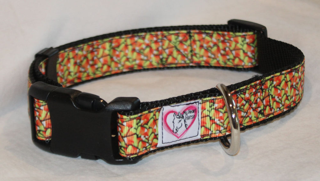 A patterned dog collar with a black plastic buckle, a silver metal ring The collar features a busy, multicolored pattern of orange, yellow, white candy corn.