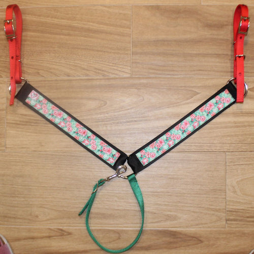 Christmas horse breast collar has red nylon tug straps, black trim, and a candy patterned center panel in red, green, and white.
