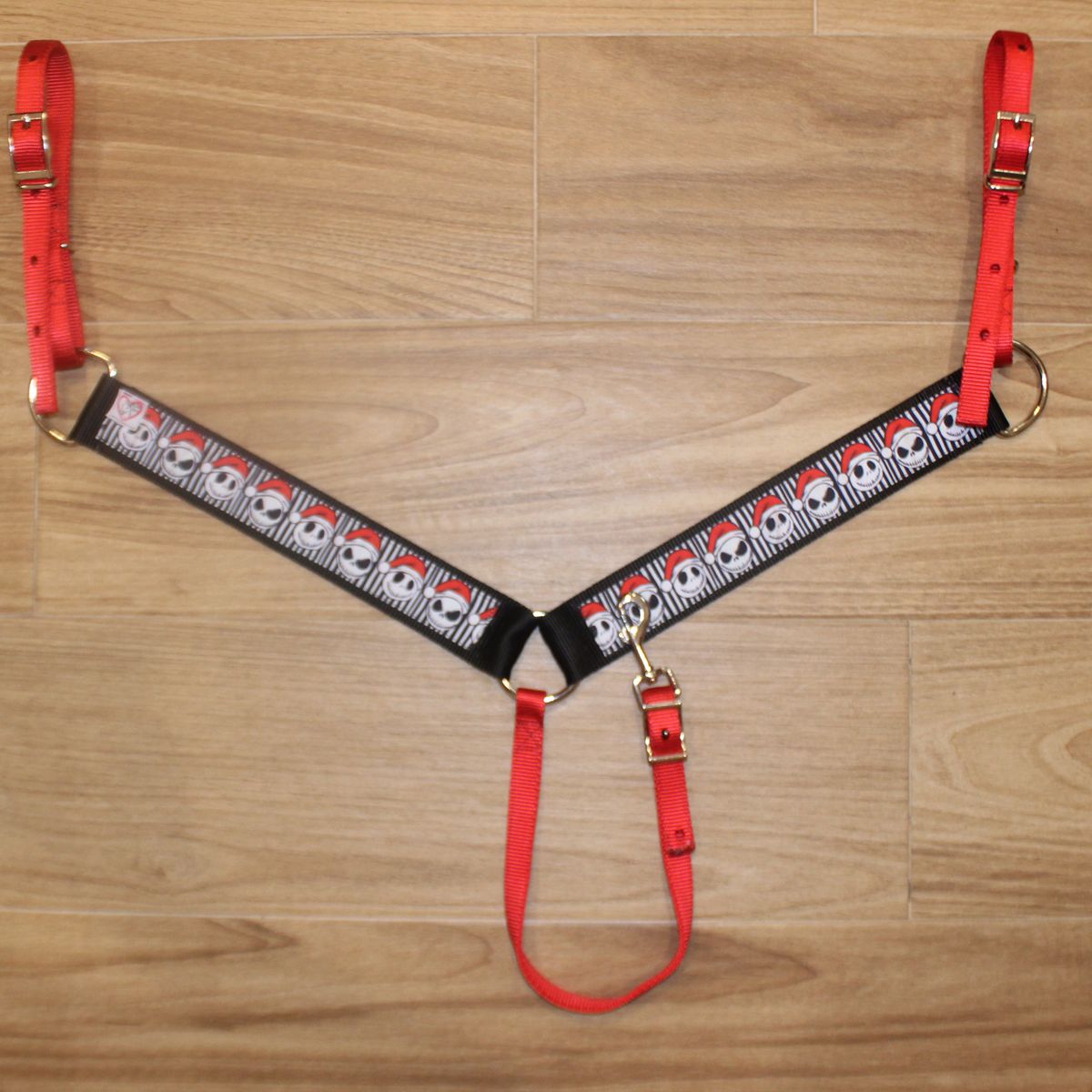 A red and black horse breast collar with a repeating skull pattern, 