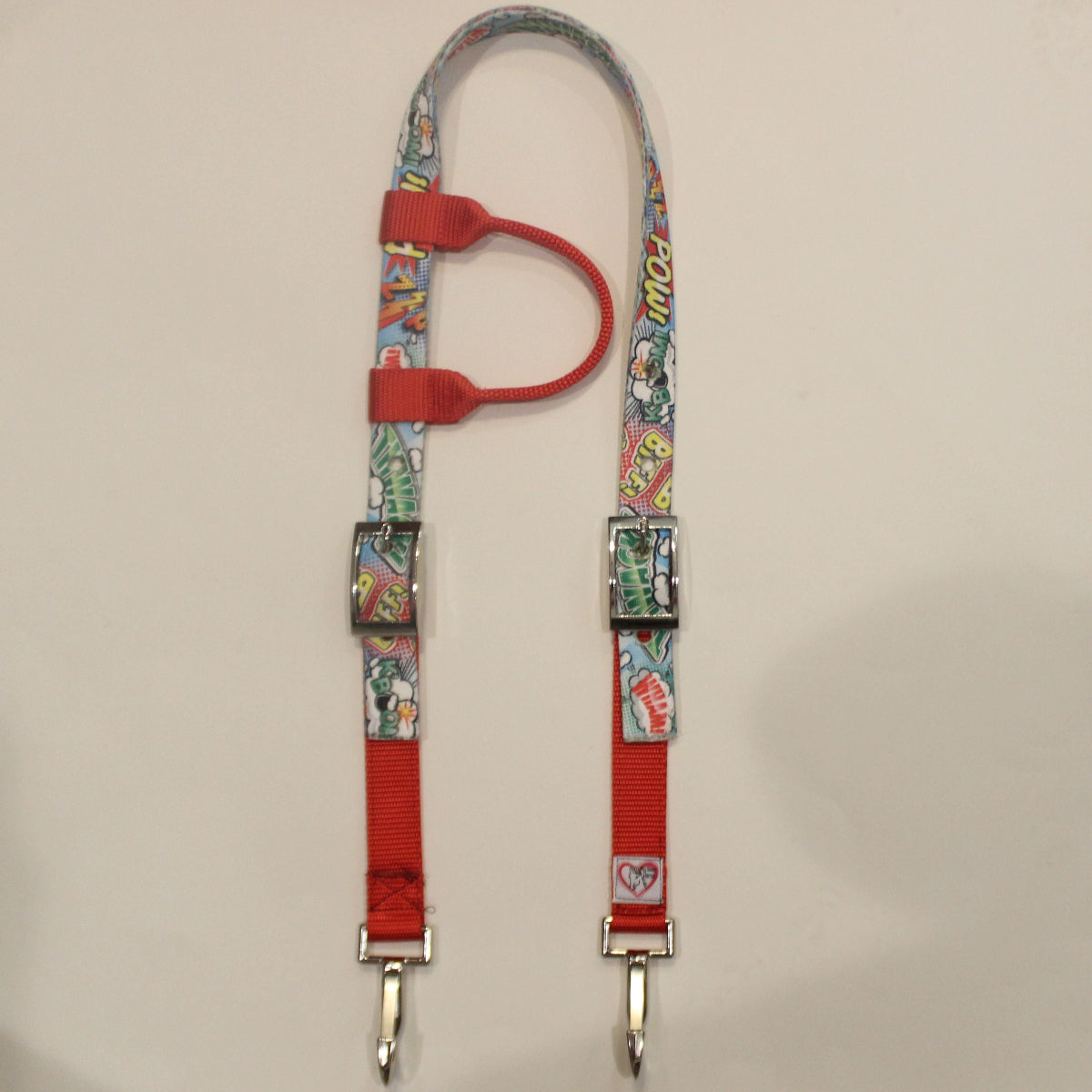 A horse headstall with a colorful comic book print strap and bright red webbing, 