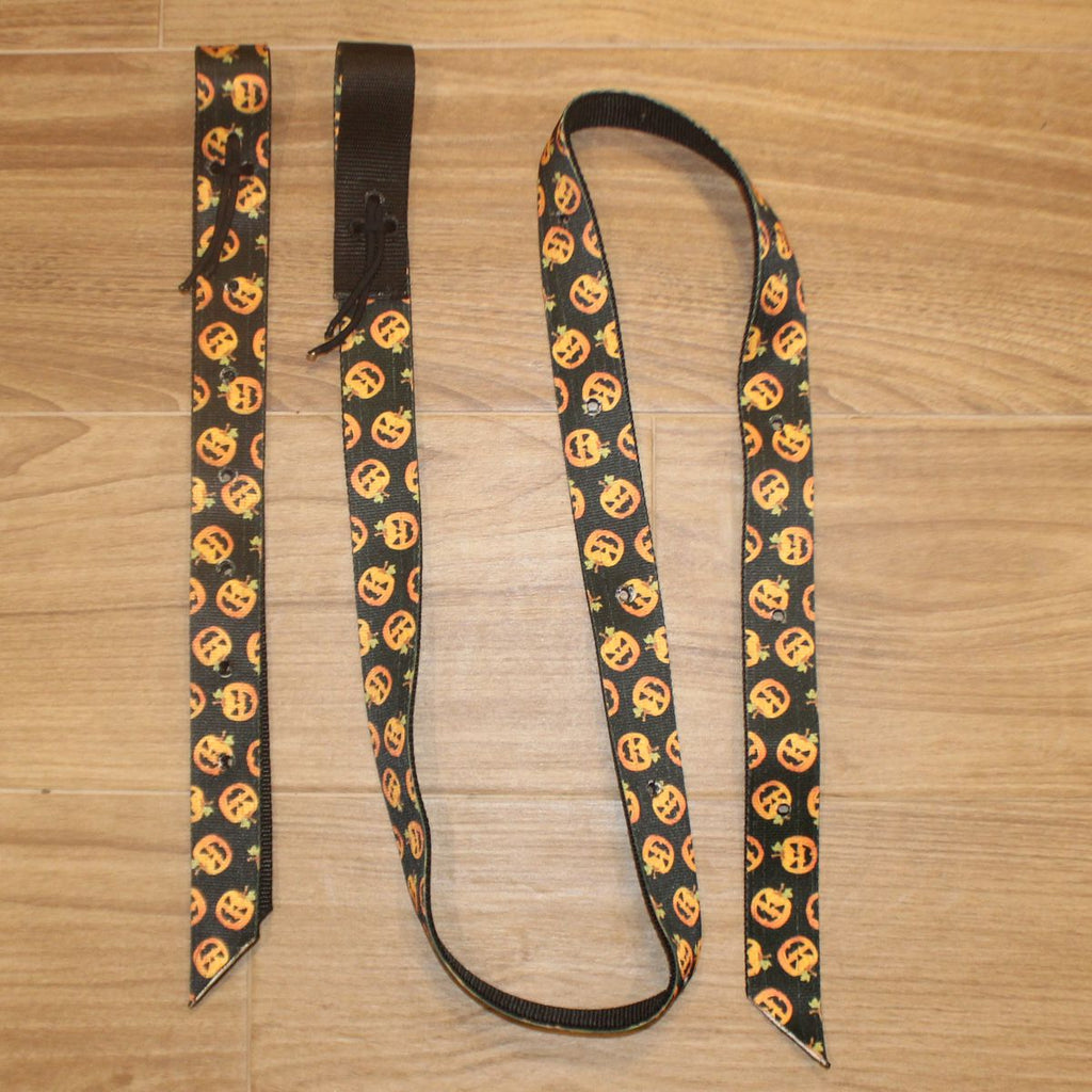 A Halloween-themed horse cinch set with a black background and a repeating pattern of orange jack-o'-lantern faces, 