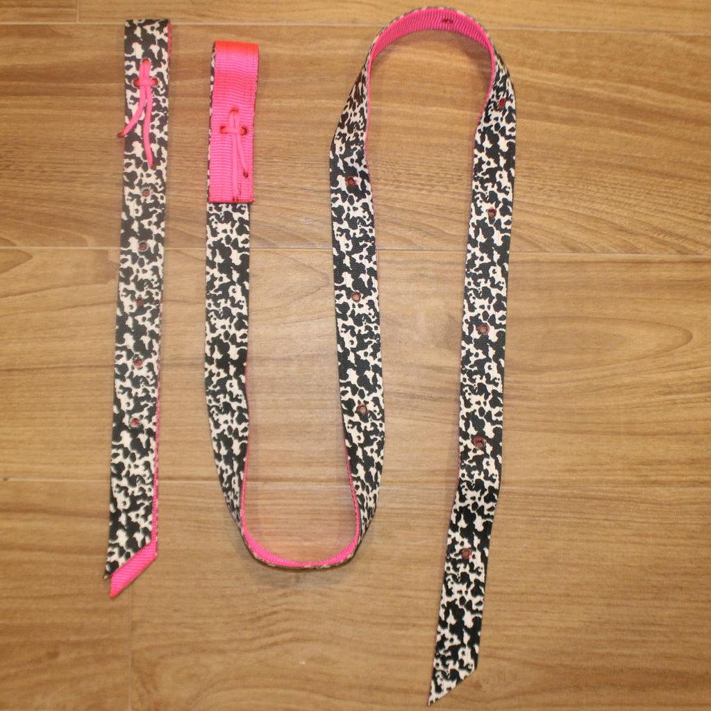 Neon Pink Cow Latigo and Billet Cinch Set, featuring a black, cow print pattern with a vibrant hot pink inner lining