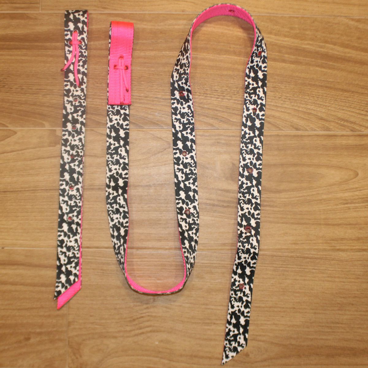 Neon Pink Cow Latigo and Billet Cinch Set, featuring a black, cow print pattern with a vibrant hot pink inner lining