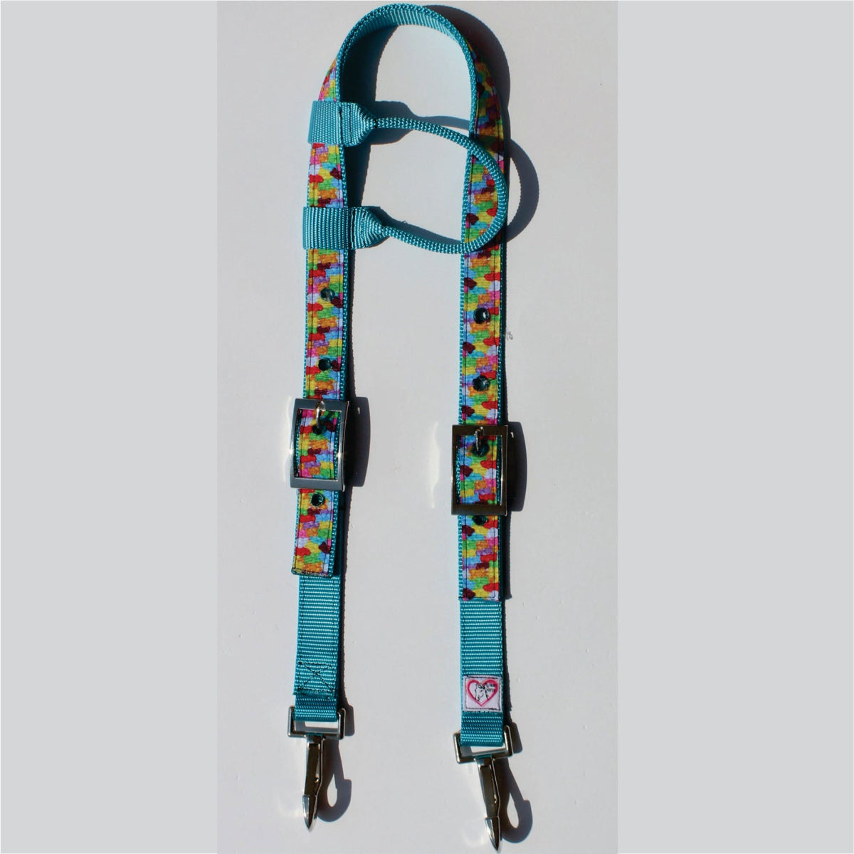 A turquoise horse headstall with a colorful gummy candy patterned strap, silver metal buckles