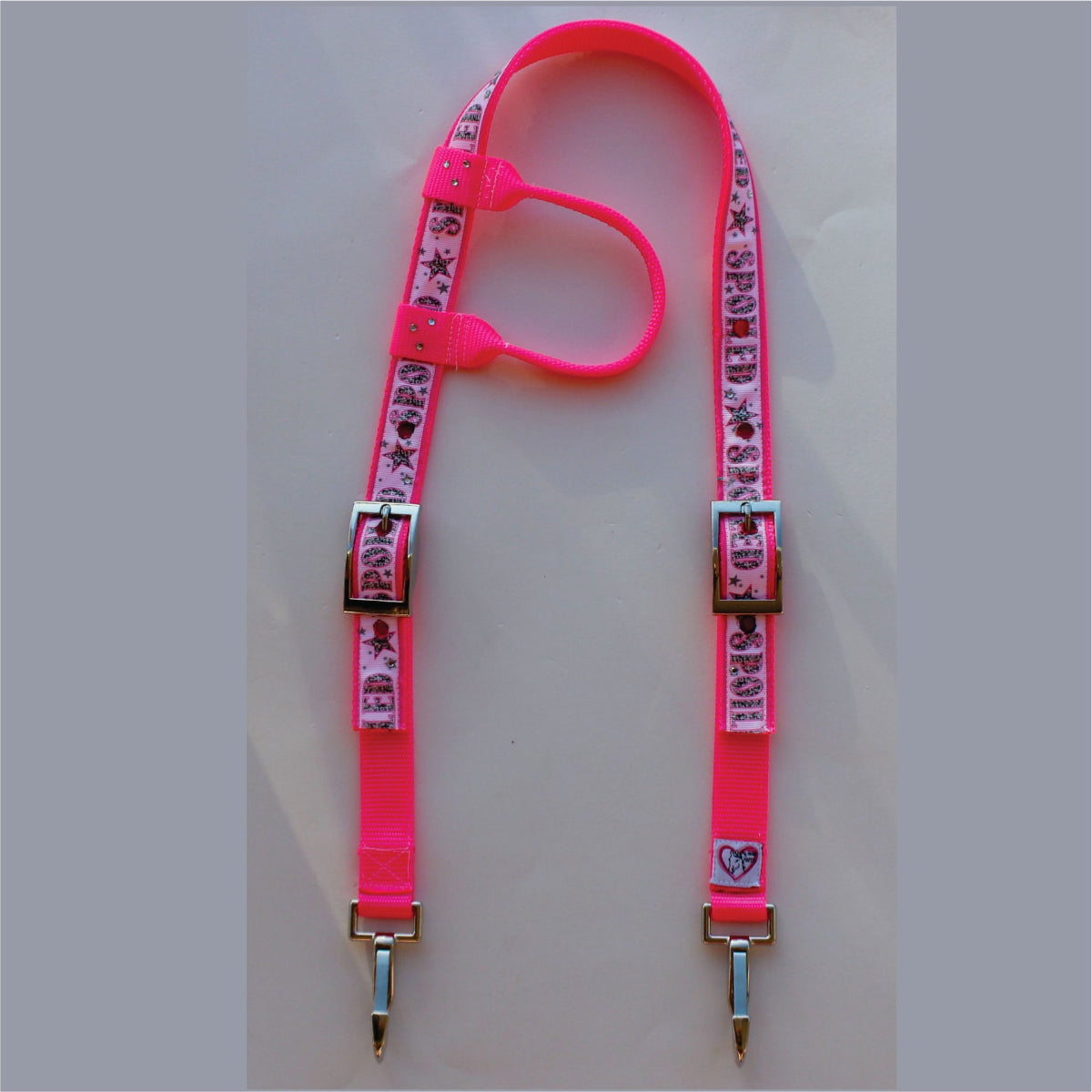 A neon pink horse headstall featuring a printed pattern of hearts, stars, and the word 'spoiled' on the webbing, finished with silver metal buckles and clips.